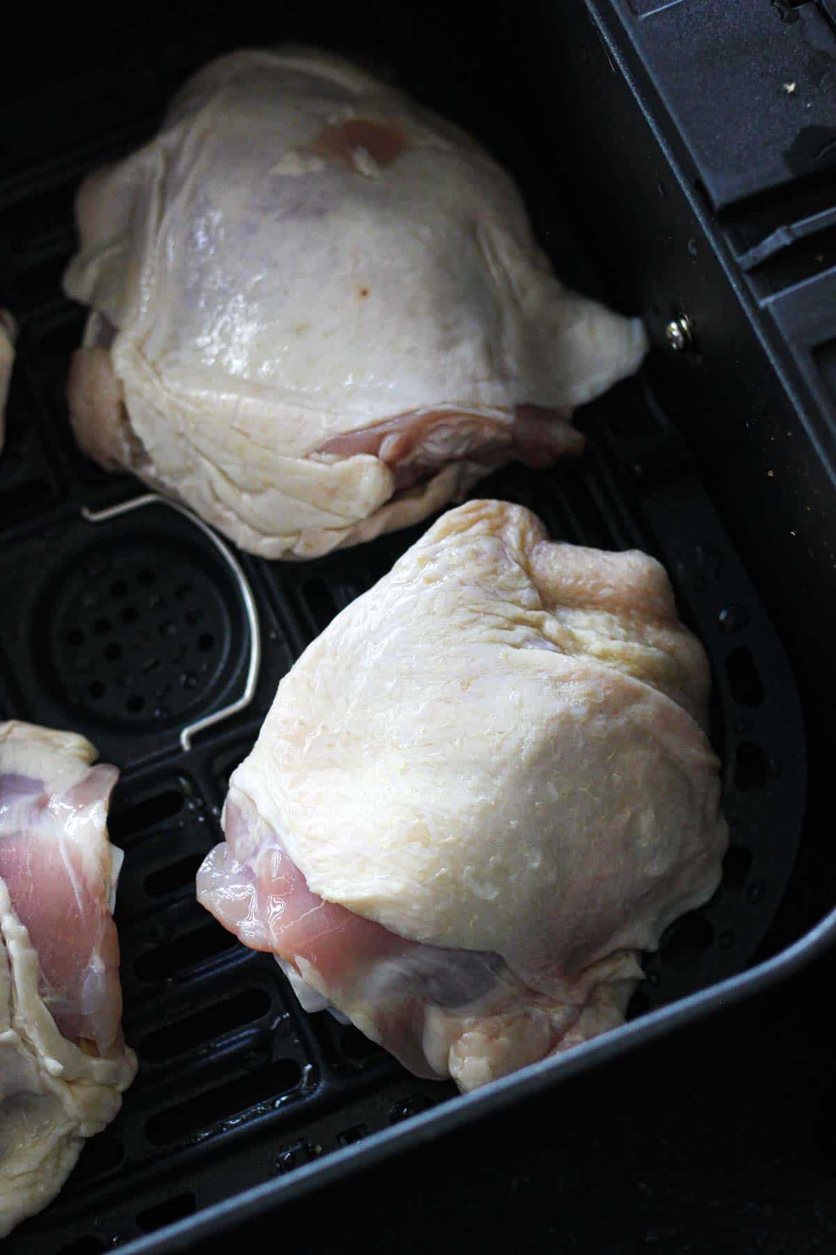 raw bone in thighs with skin on in the cooking pan