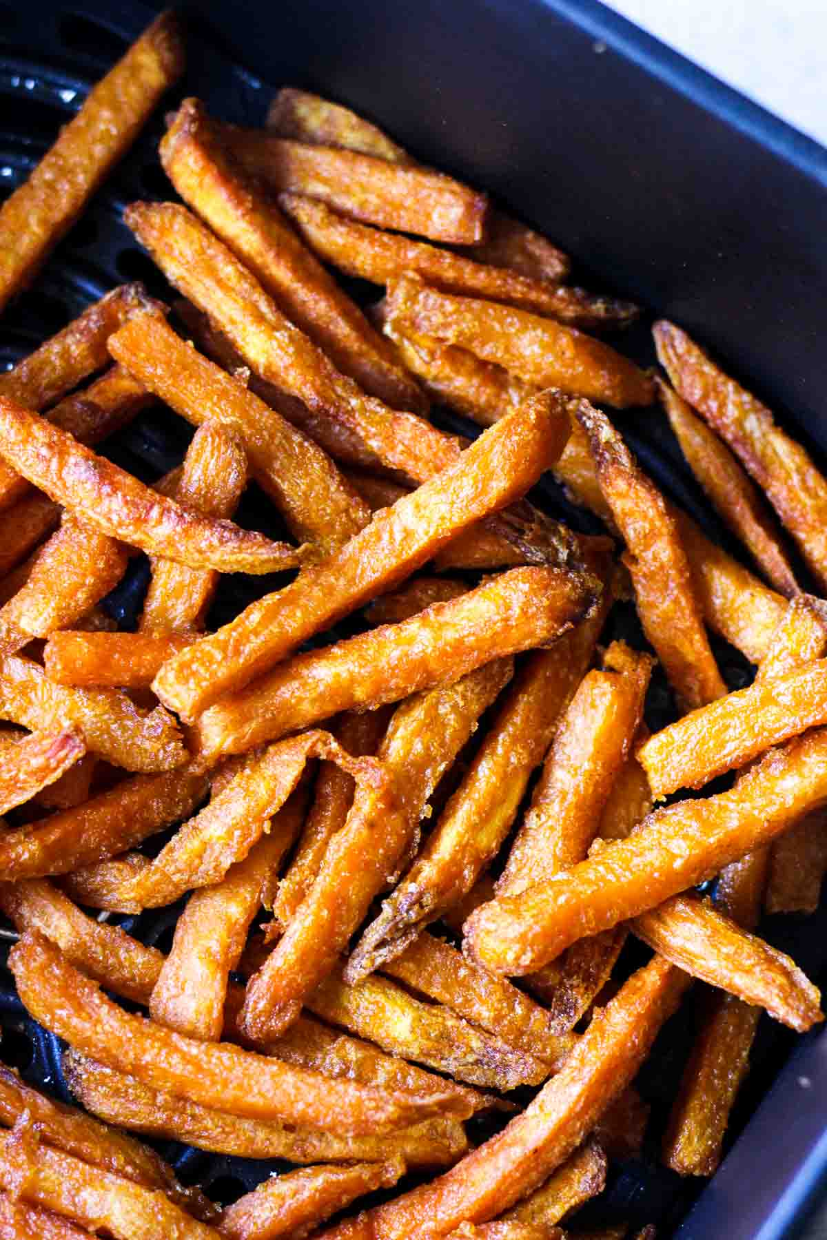 cooked crispy fries in black air fryer basket