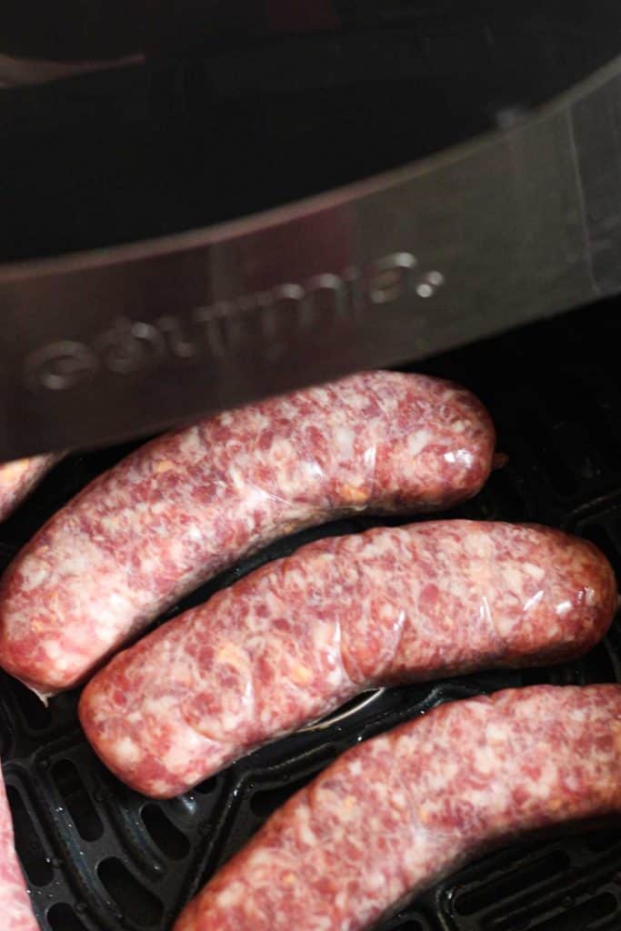 raw cheddar brats in air fryer basket