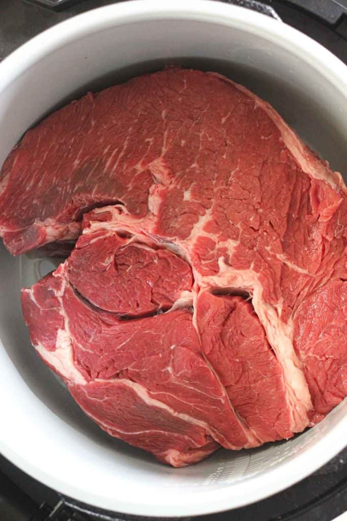 raw beef chuck roast in the pressure cooker inner pot