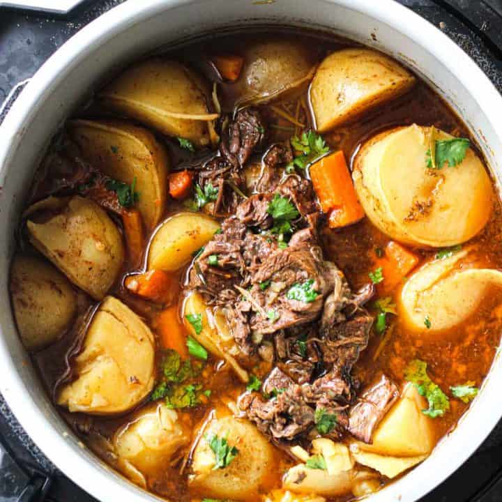 coked beef pot roast in pressure cooker with potatoes and carrots