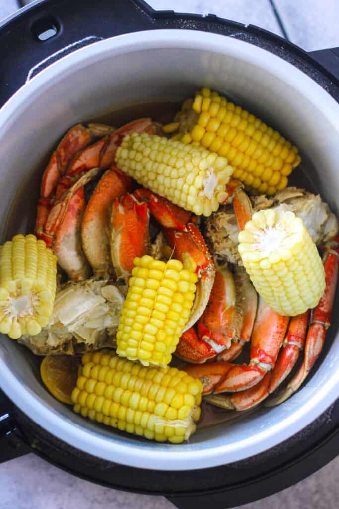 cooked corn on the cob and crab legs in pressure cooker