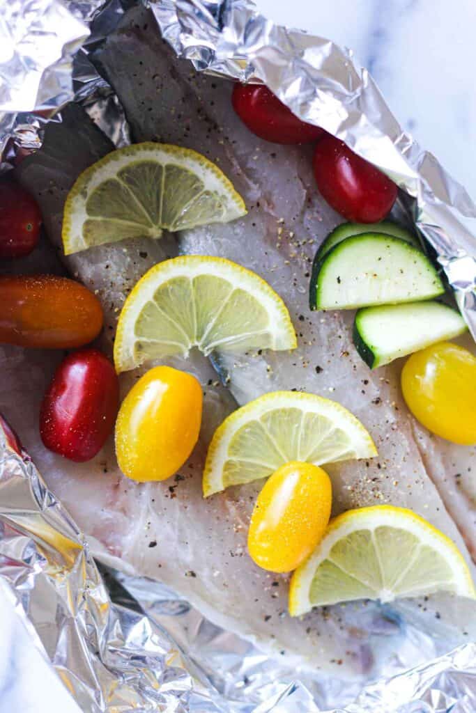 raw branzino with vegetables wrapped in foil