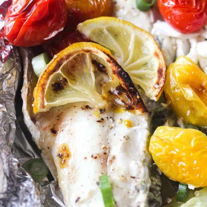 close picture of branzino fish with roasted cherry tomatoes on top