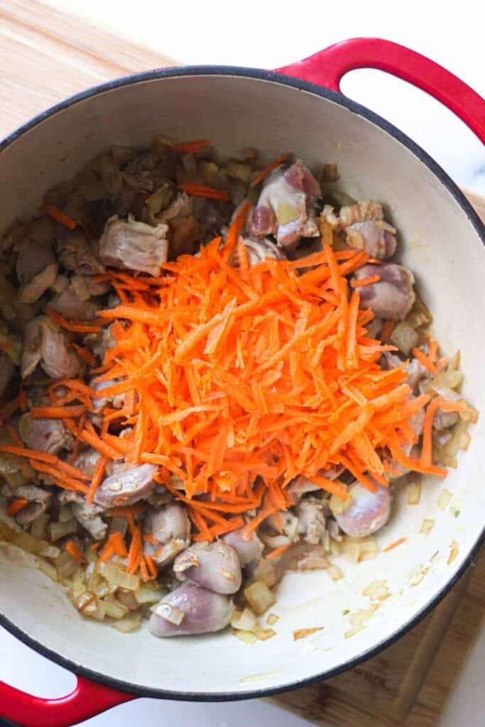shredded carrots on top of chicken gizzards and hearts