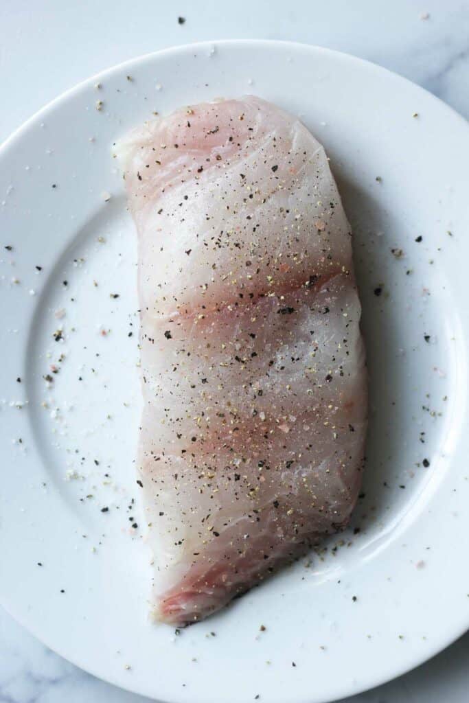 raw grouper fillet with salt and ground pepper