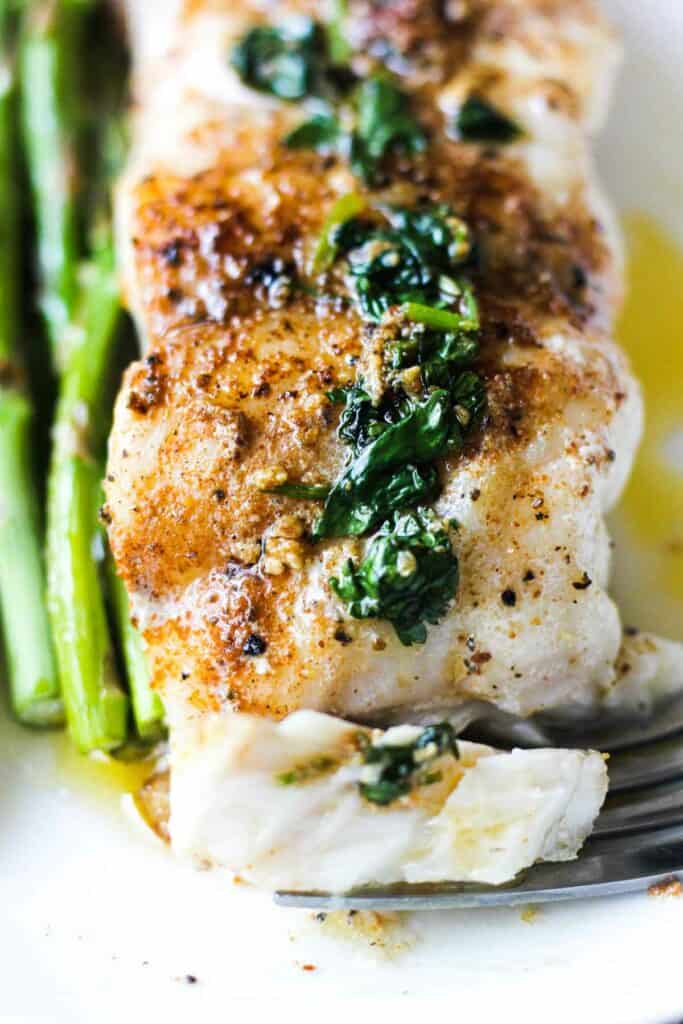 a slice of pan fried grouper fillet with asparagus