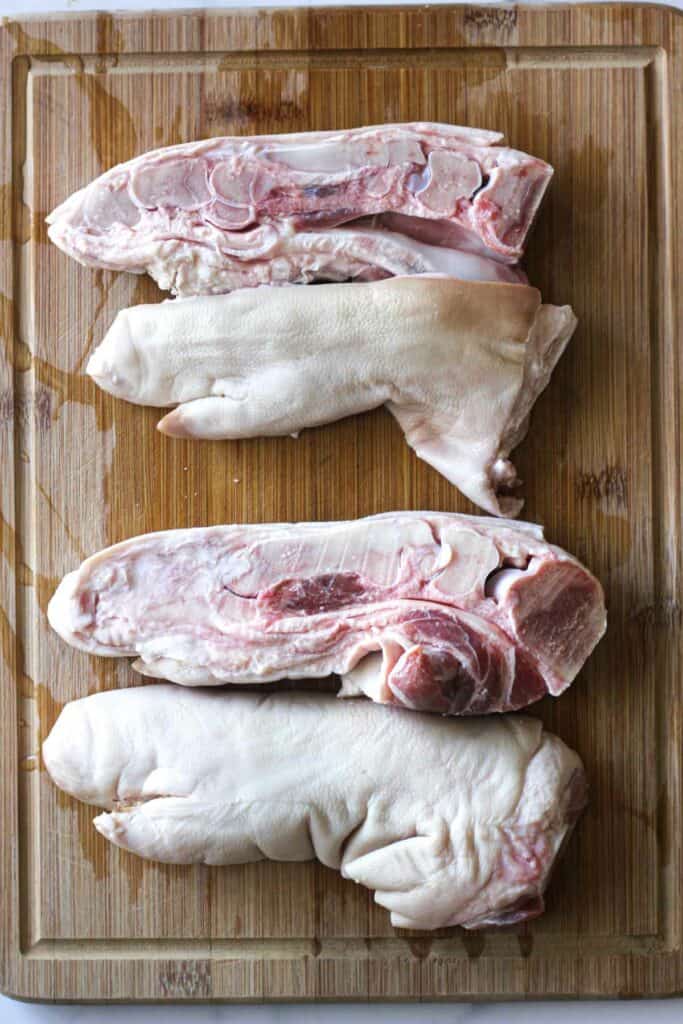 raw pig feet sliced on a cutting board