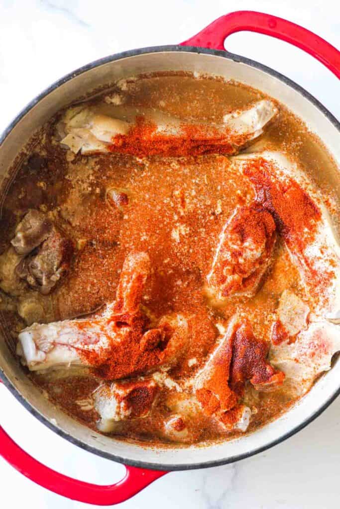 process of cooking stew in the large red pot