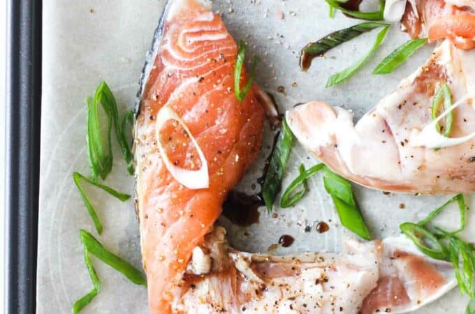 raw salmon kama with chopped scallions on the parchment paper
