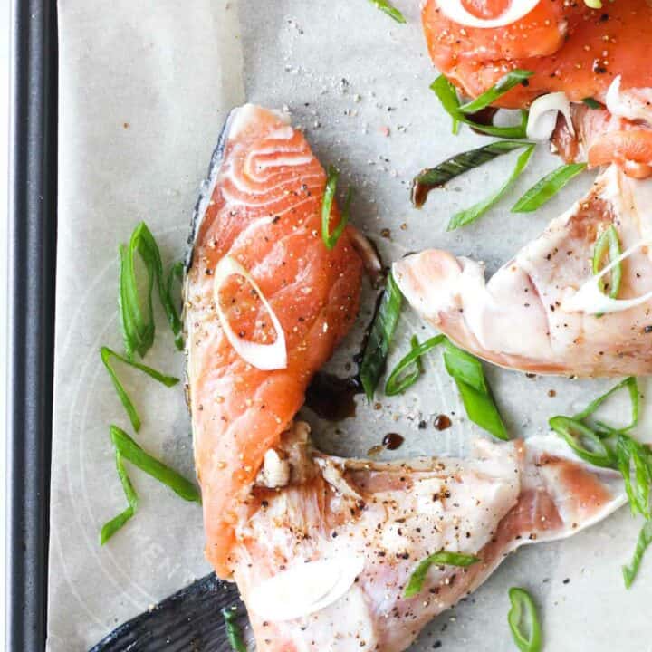 raw salmon kama with chopped scallions on the parchment paper