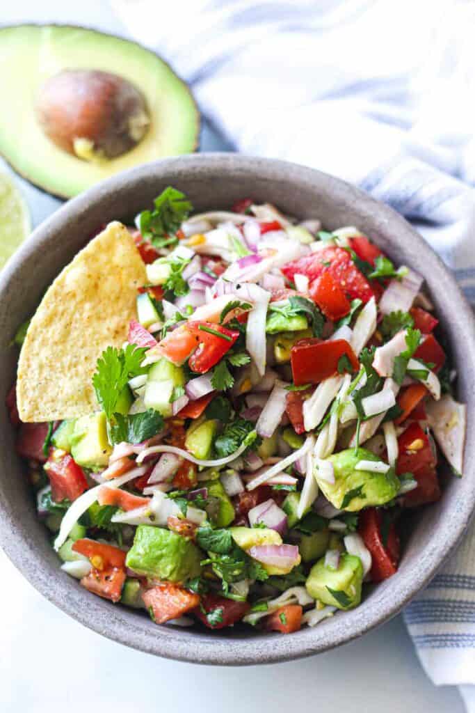 crab ceviche with avocado, tomatoes, cucumbers, lime juice, onion and cilantro in a serving bowl