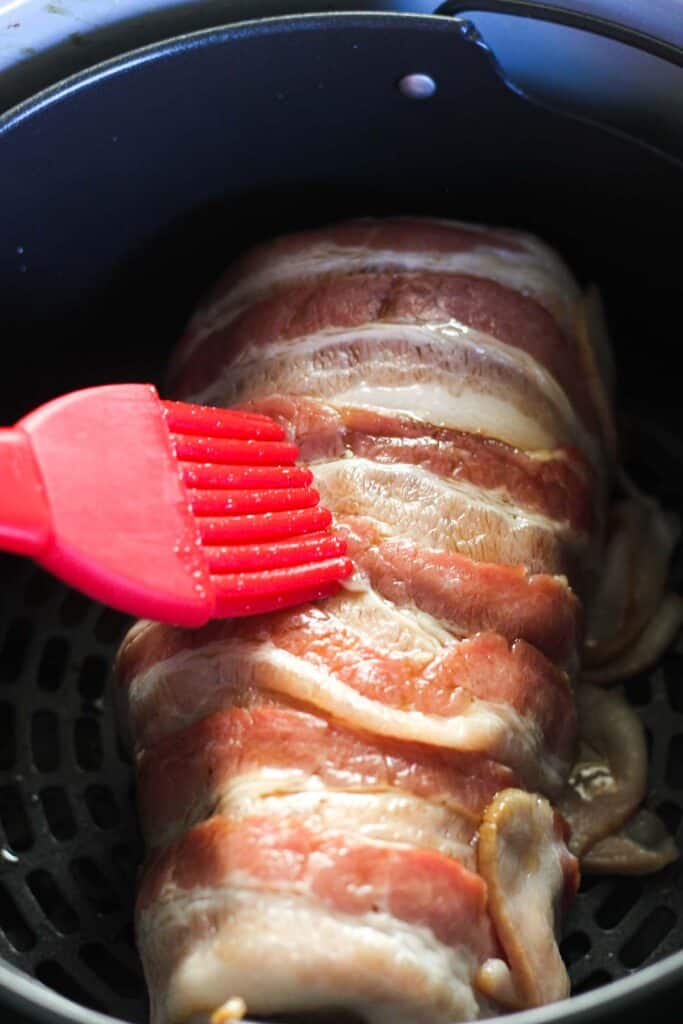 brushing maple syrup on top of bacon