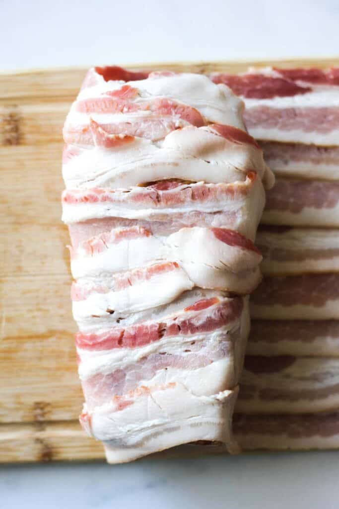 process of wrapping pork in bacon