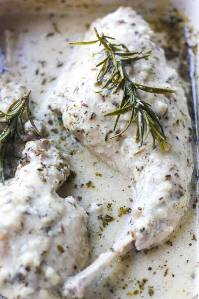 rabbit legs baked in cream sauce with fresh rosemary on top