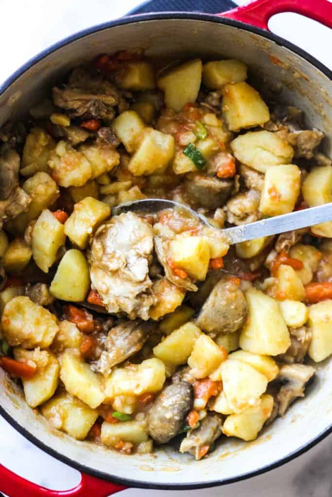 rabbit stew cooked on the stove with mushrooms and potatoes
