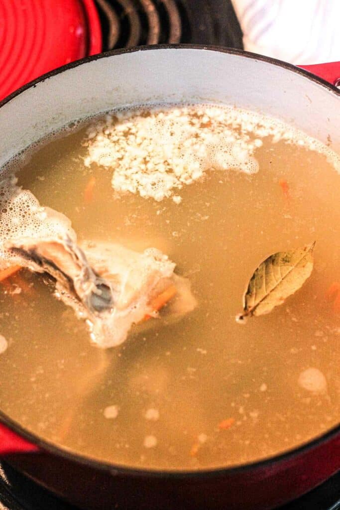 simmering noodle soup with rabbit meat in a red pot