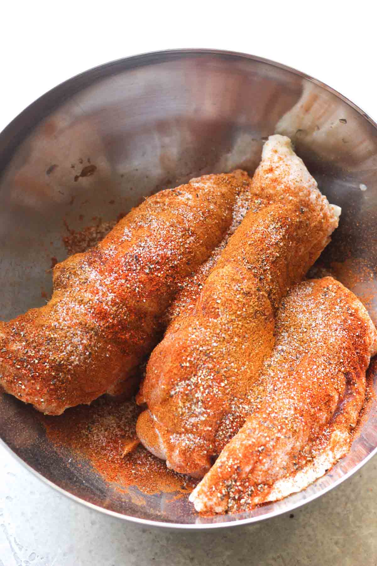raw seasoned poultry in the large bowl