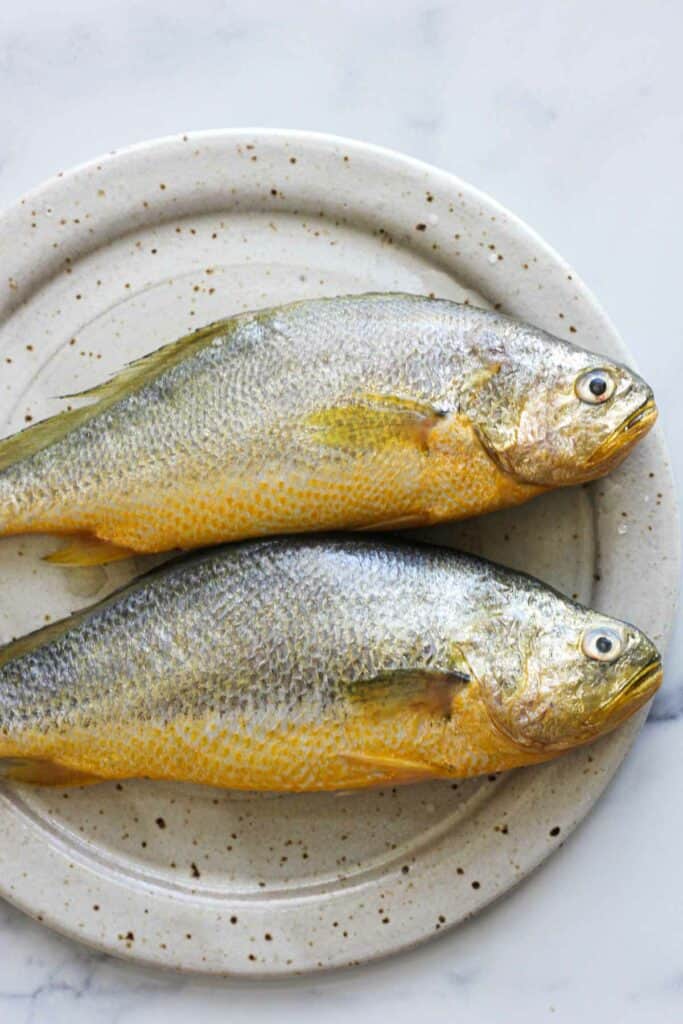 two yellow croaker fishes on the plate