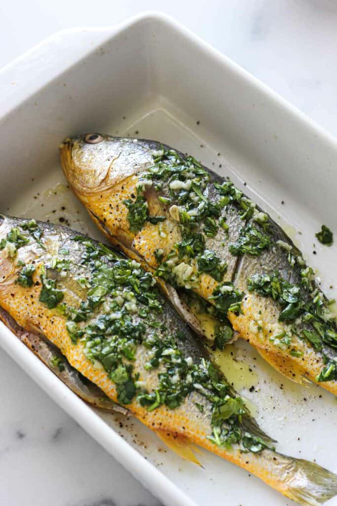 raw croaker on a baking dish before baking