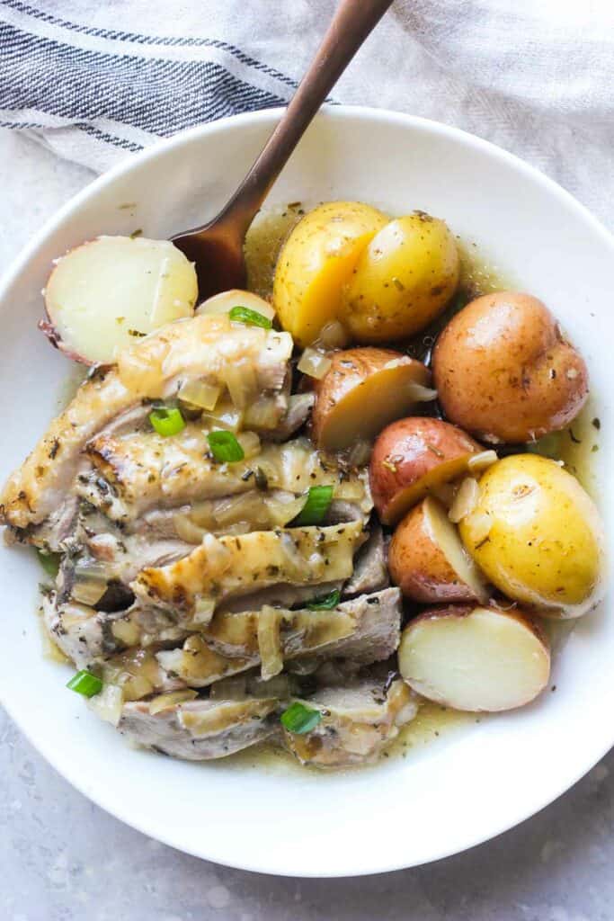sliced turkey thigh with baby potatoes on the plate