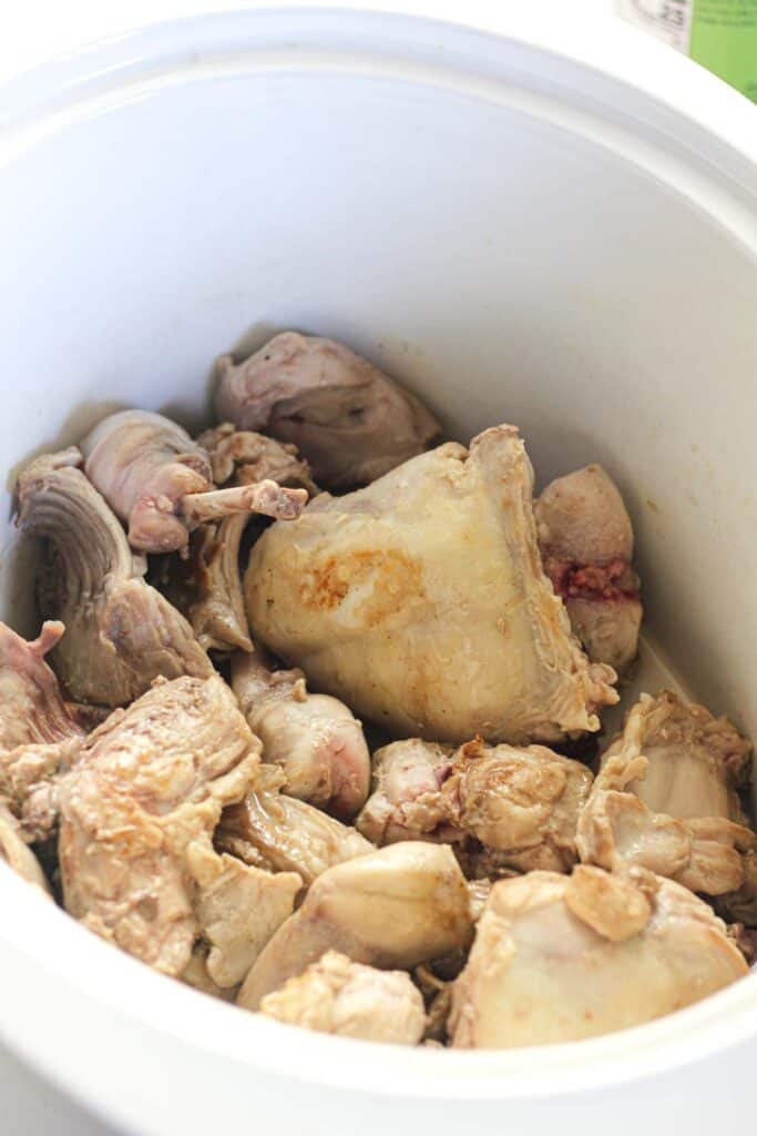 browned rabbit pieces in slow cooker