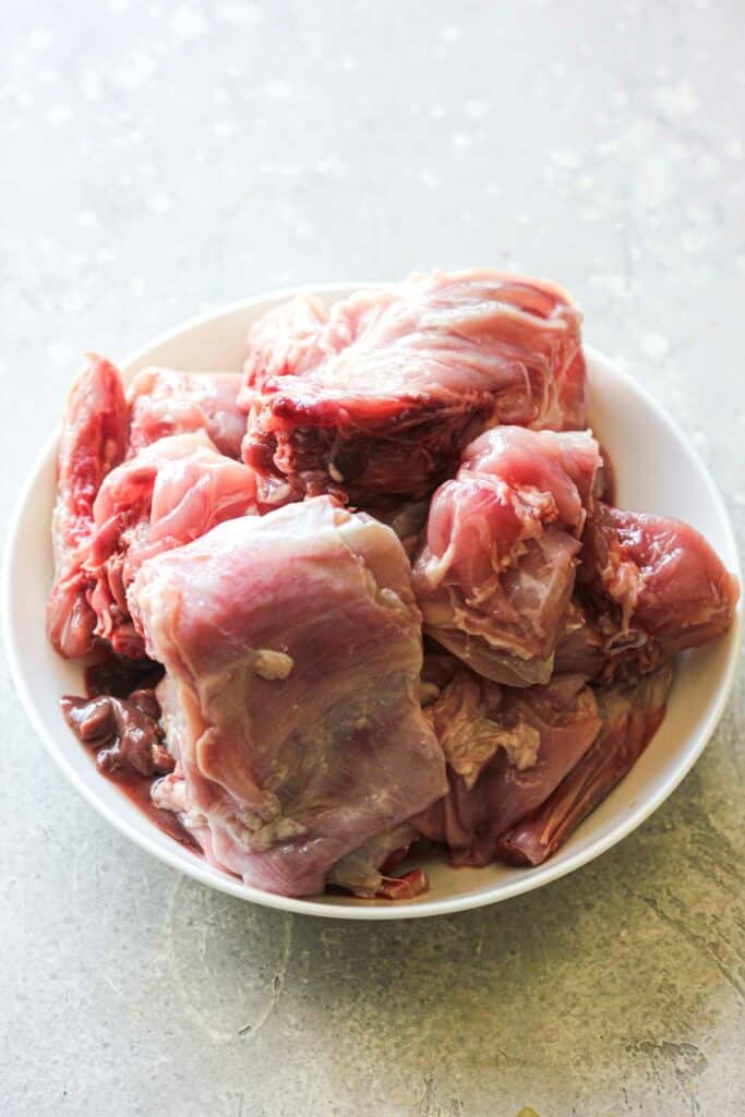 chopped rabbit in pieces in a white bowl