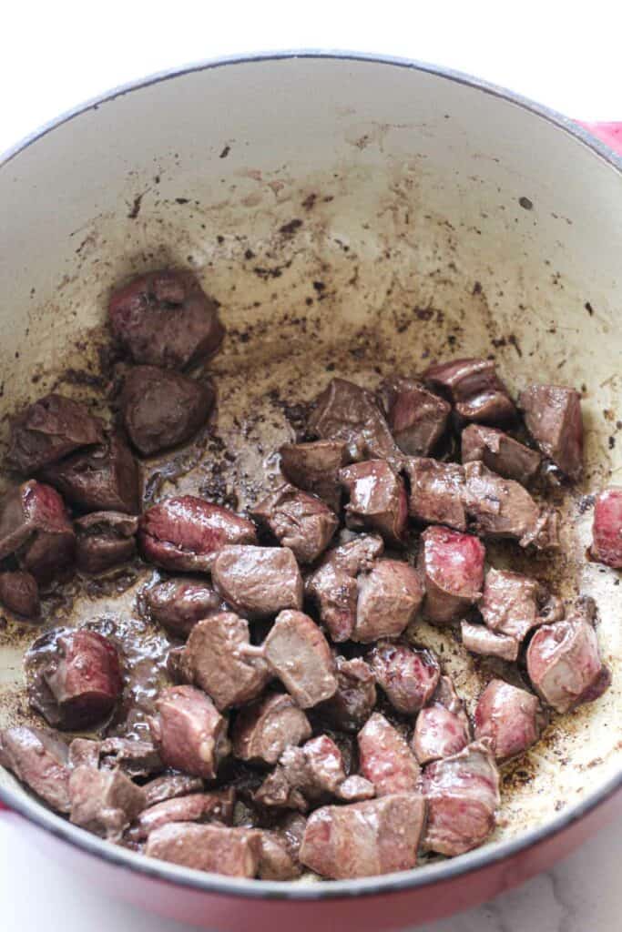 browned lamb in a heavy bottom pot