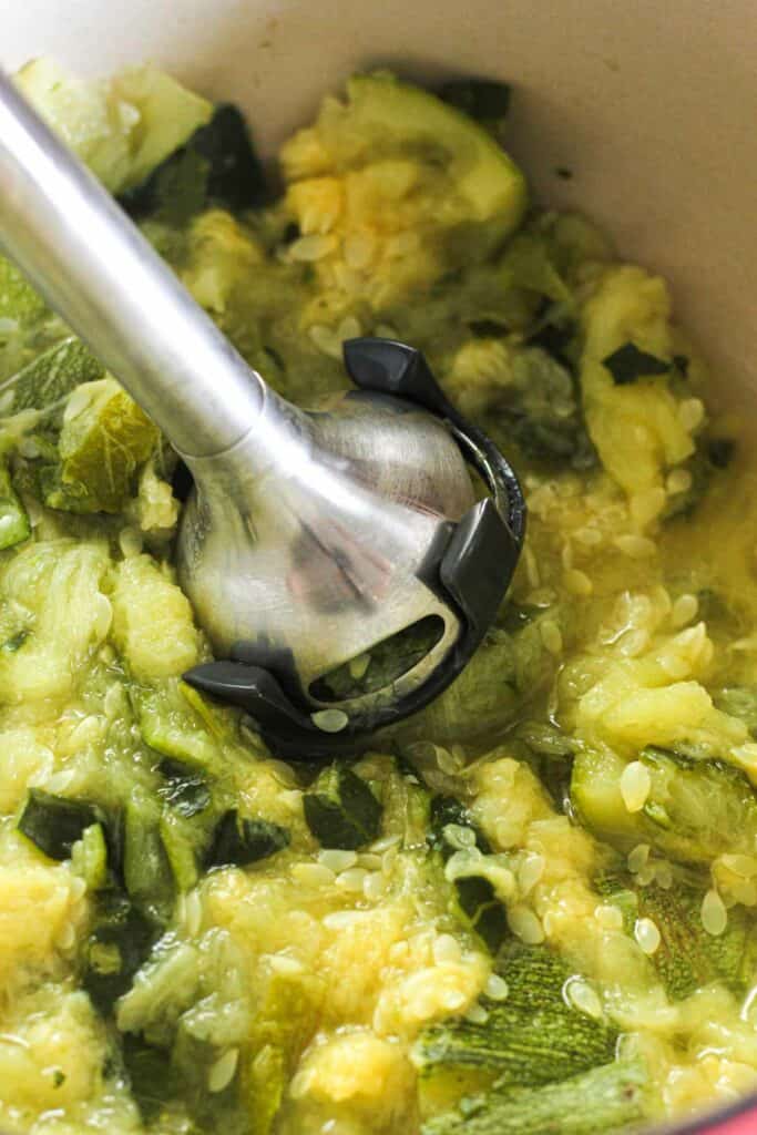 mashing zucchini with immersion blender