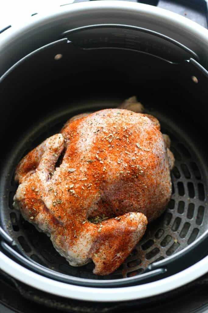 raw seasoned poultr bird in ninja foodi air fryer basket
