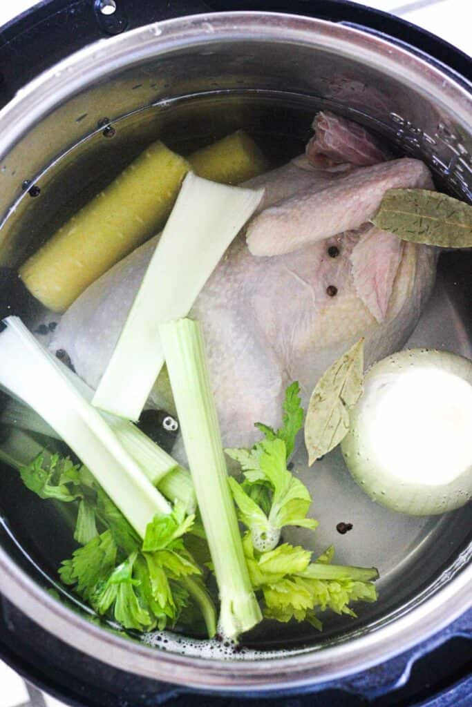 raw chicken with vegetables in a pressure cooker pot