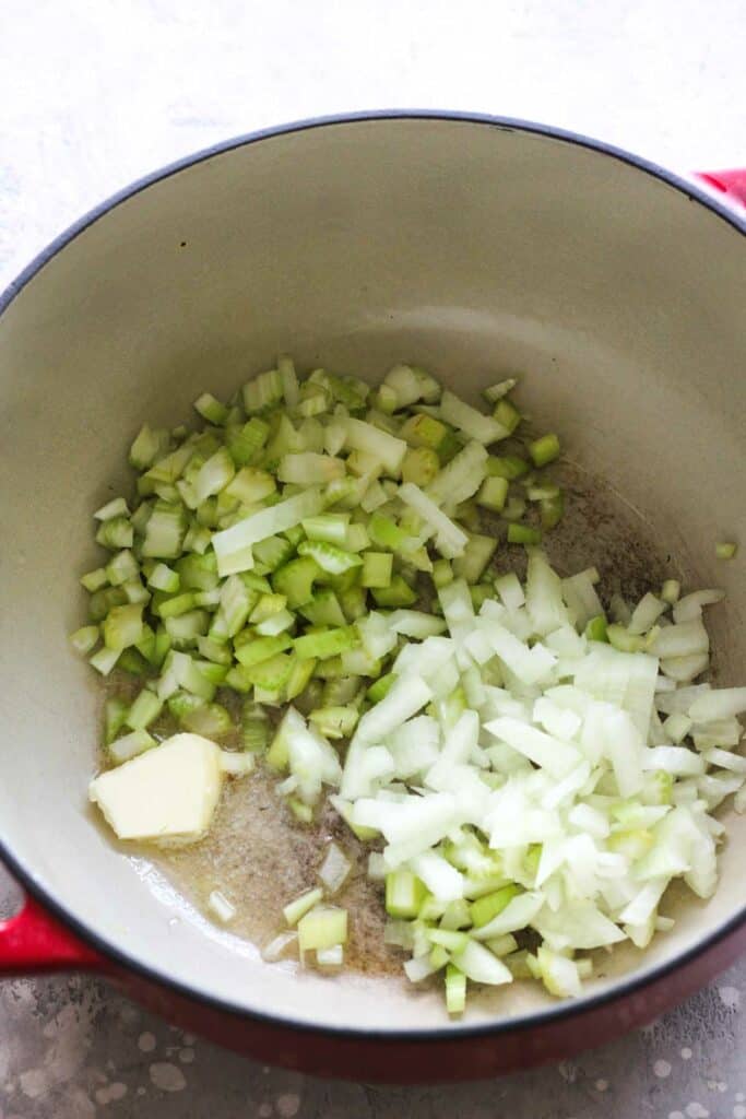 chopped onions and celery in a red pot
