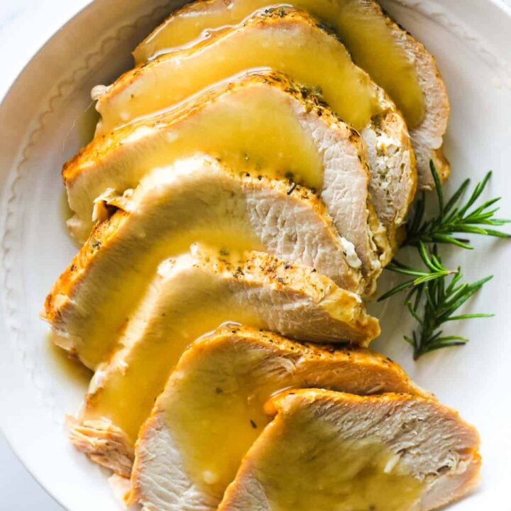sliced turkey breast with yellow gravy on top