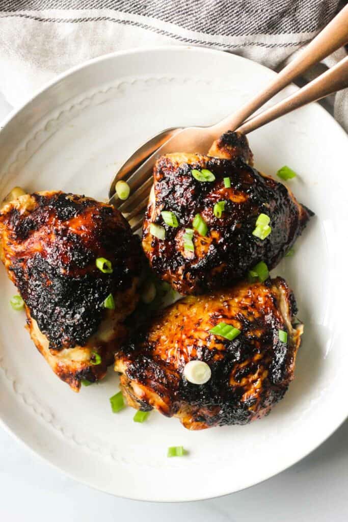 three bbq thighs cooked in air fryer with chopped green onions on top