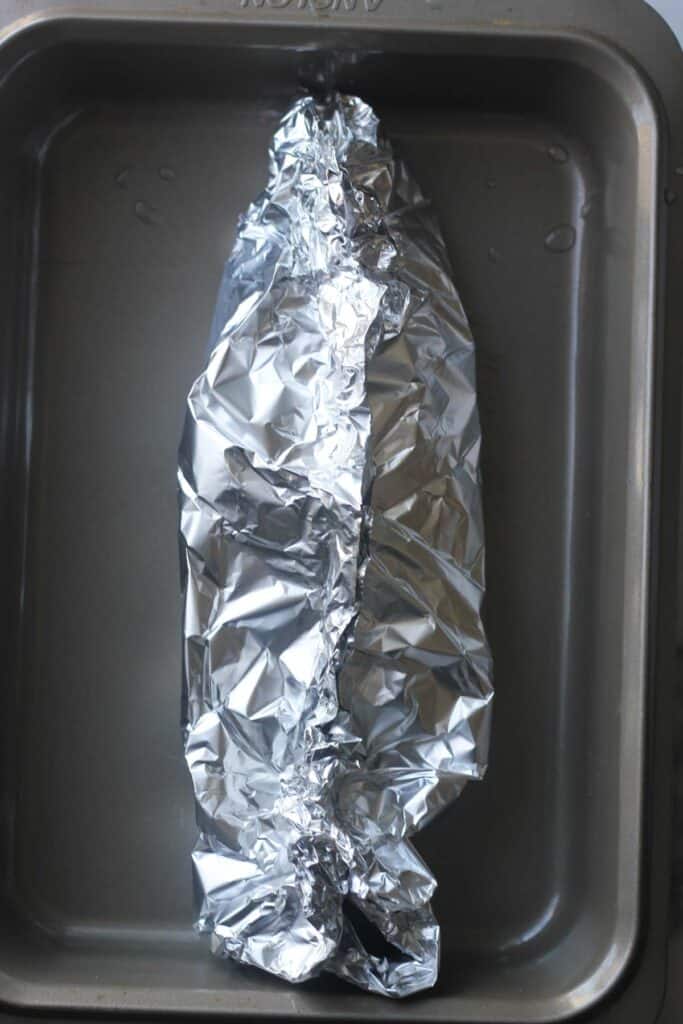 fish wrapped in foil in the oven cooking tray