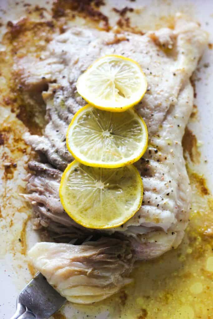 oven baked skate with lemon butter salt and pepper, a piece on a fork