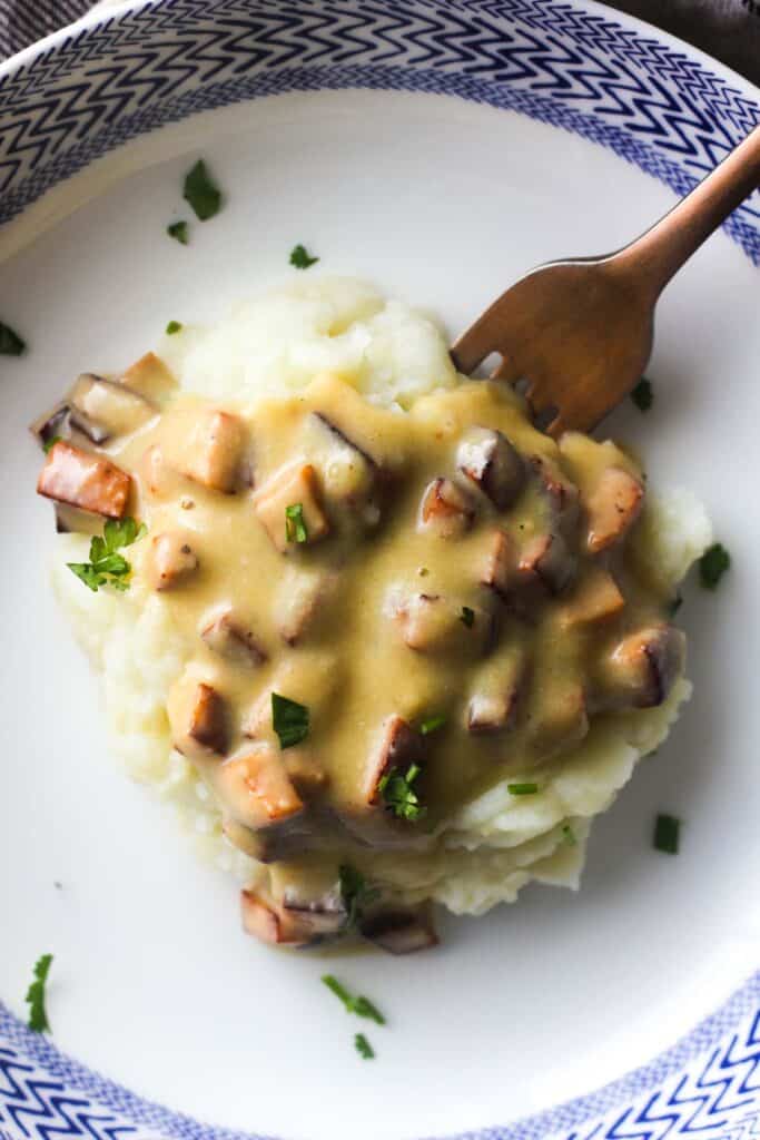 bolognan gravy with mashed potatoes in the white and blue plate