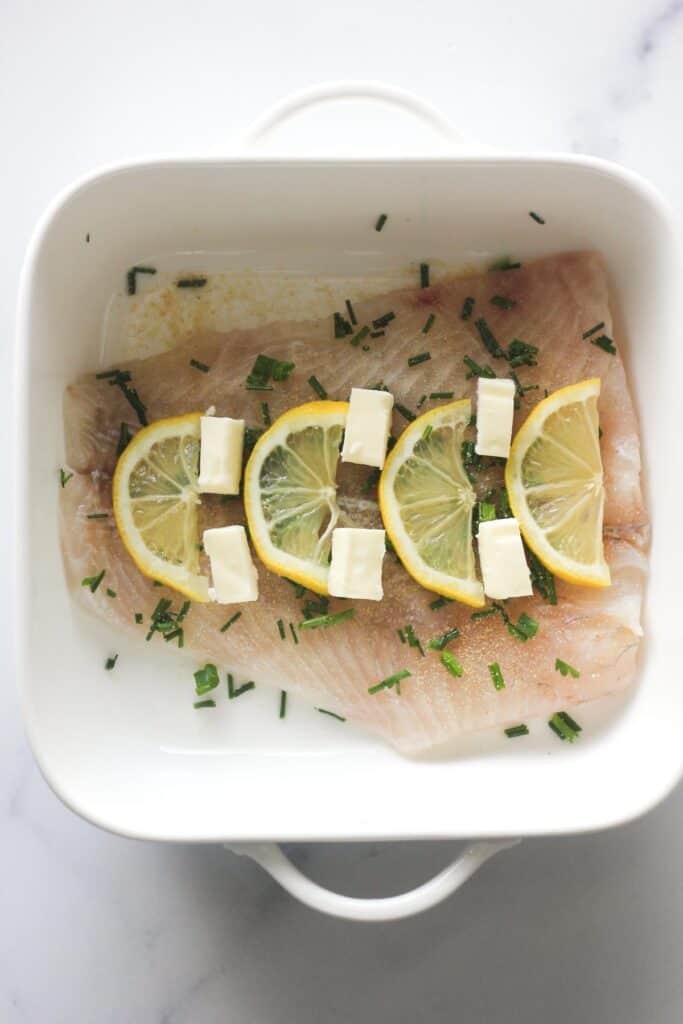 seasoned raw white fish with lemon and butter cubes