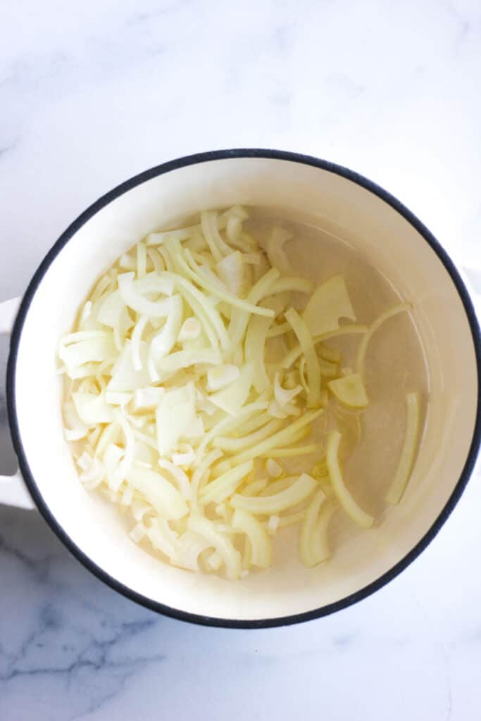 sliced onions in the white heavy pot