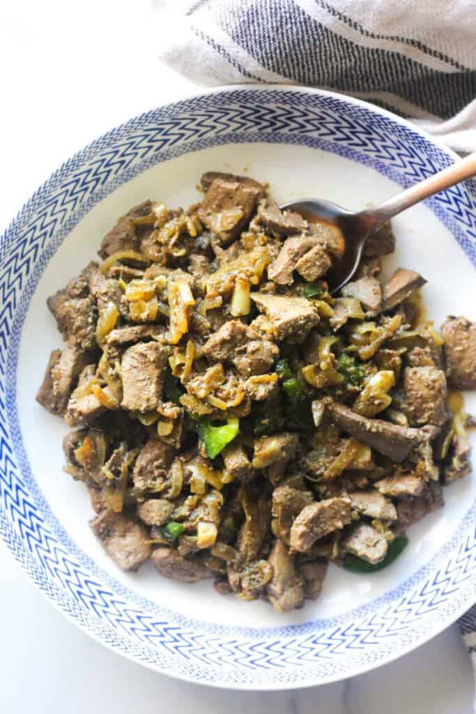 lamb liver with onions and spicy peppers on the plate
