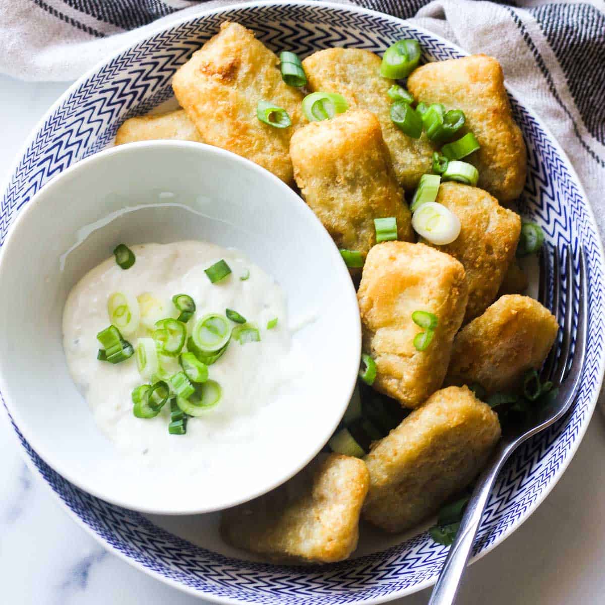 fried fish nuggets on the plate with chopped green onions
