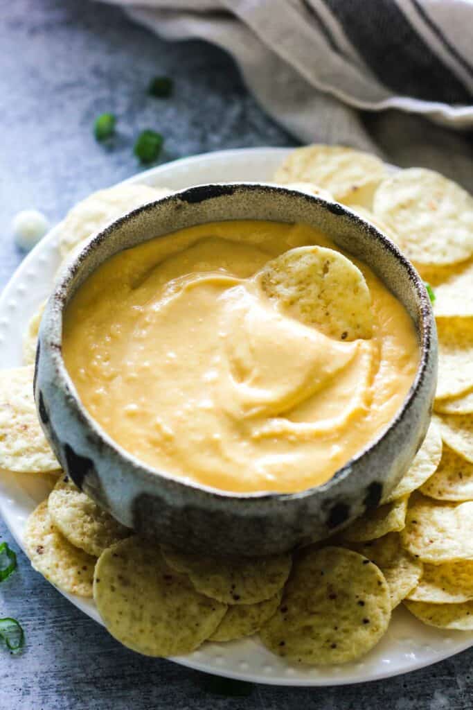 yellow cheese dip in the bowl with chips