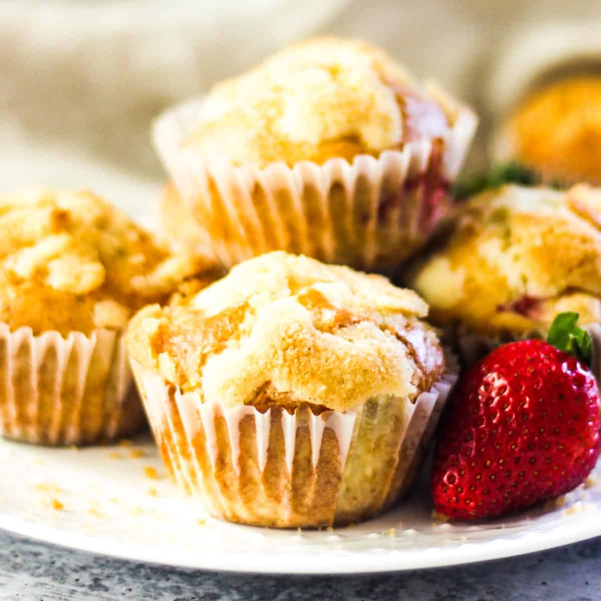 close picture of strawberry bisquick muffins on the plate with strawberries