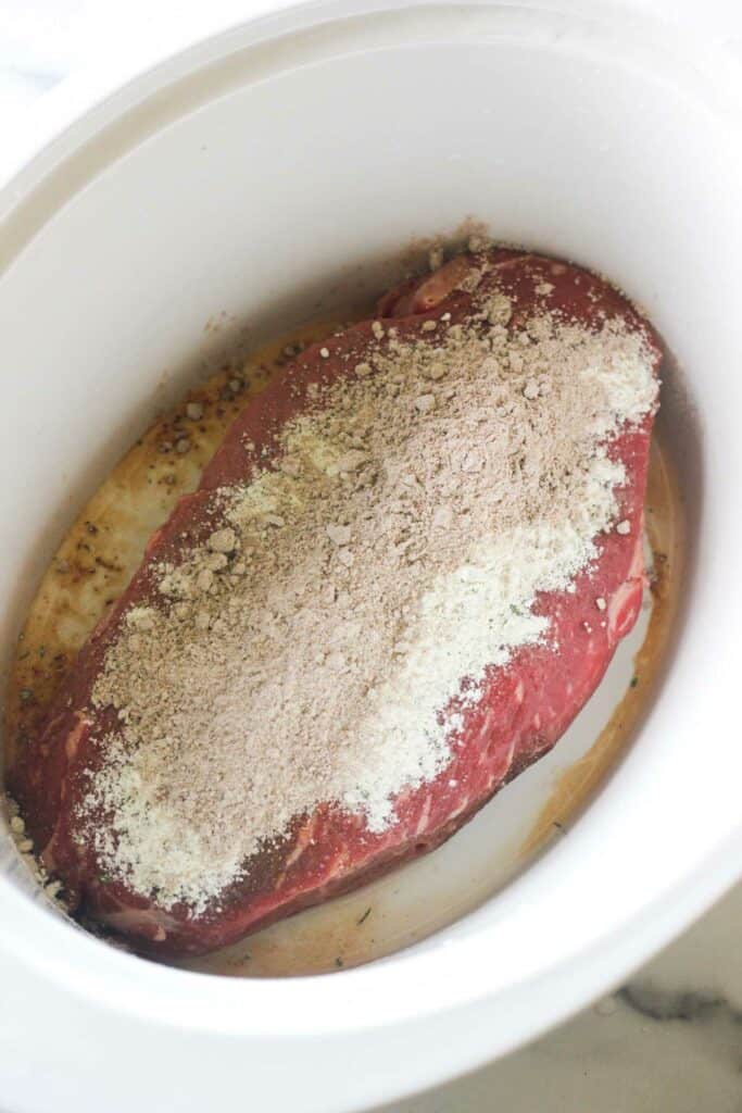 a large piece of red meat covered in spices