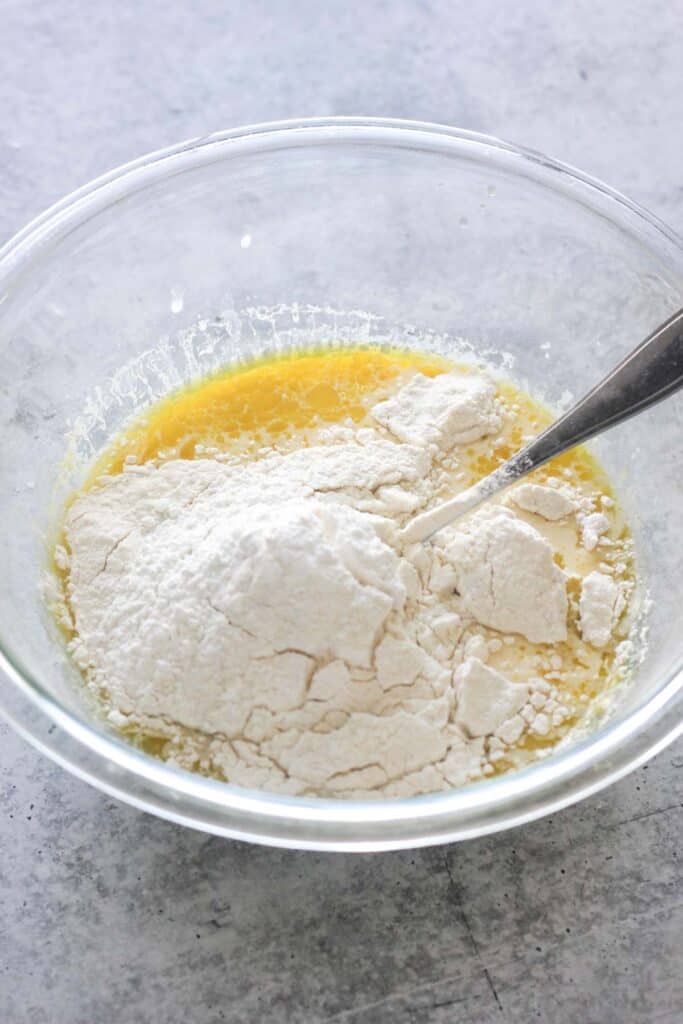 mixing milk, eggs, flour in the large glass bowl
