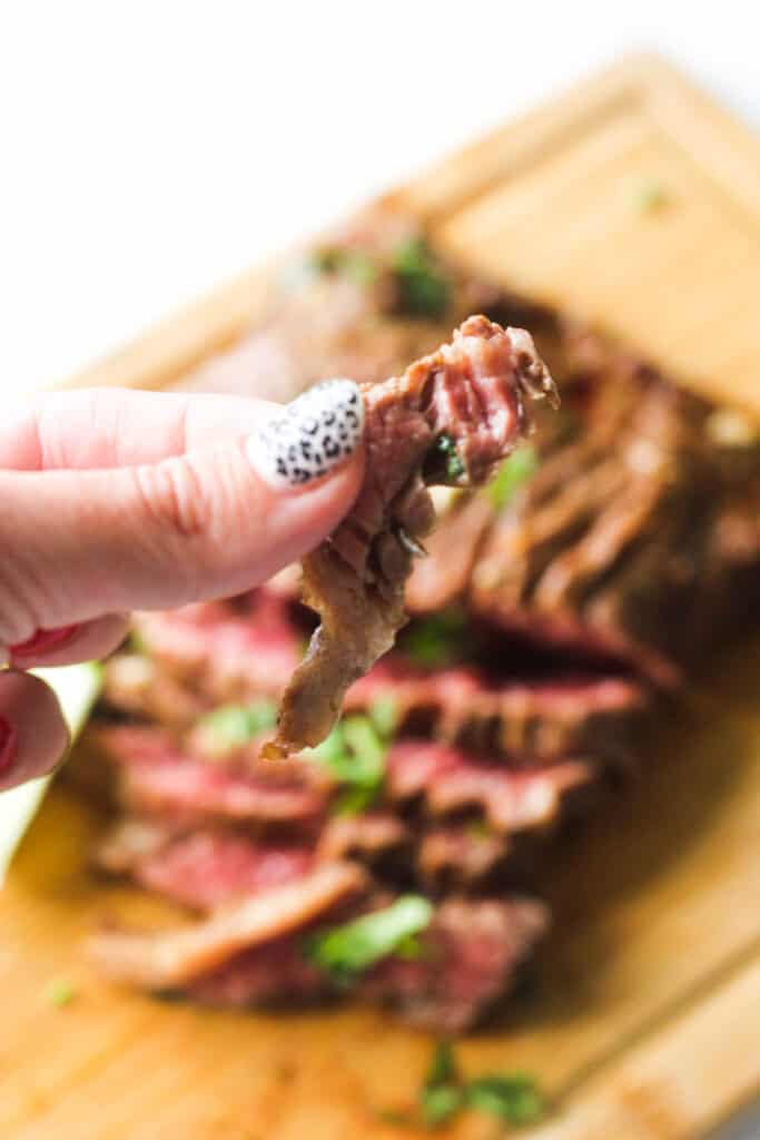 a piece of carne asada steak in hand