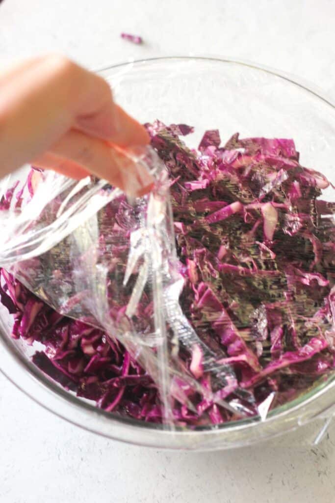 placing a plastic film on tp of the salad before marinating