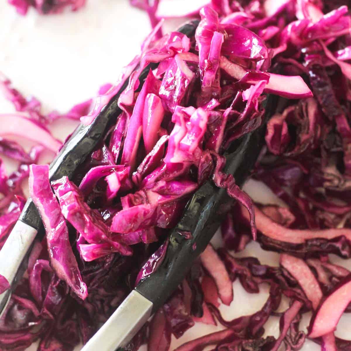 marinated red cabbage salad picked with tongs