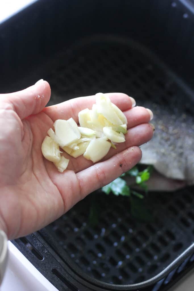 smashed garlic cloves in hand