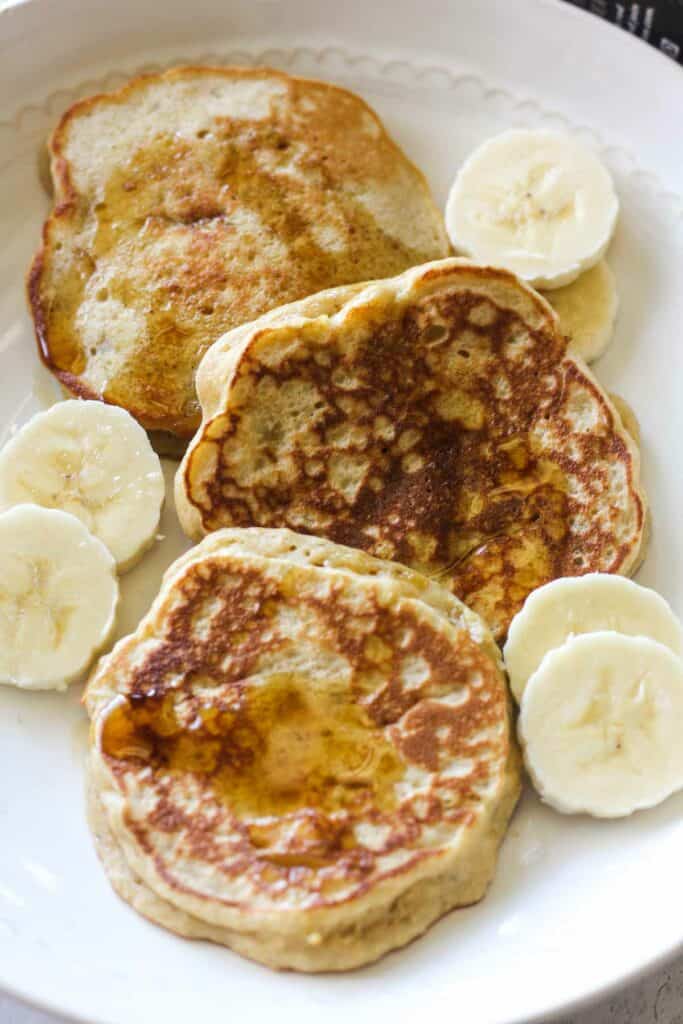 kodiak cakes banana pancakes with maple syrup on the white plate